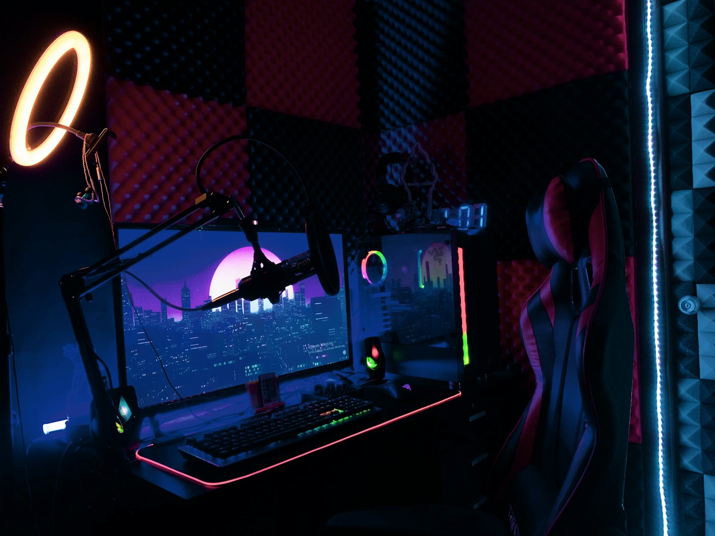 Modern gaming setup with computer, monitor, and microphone.