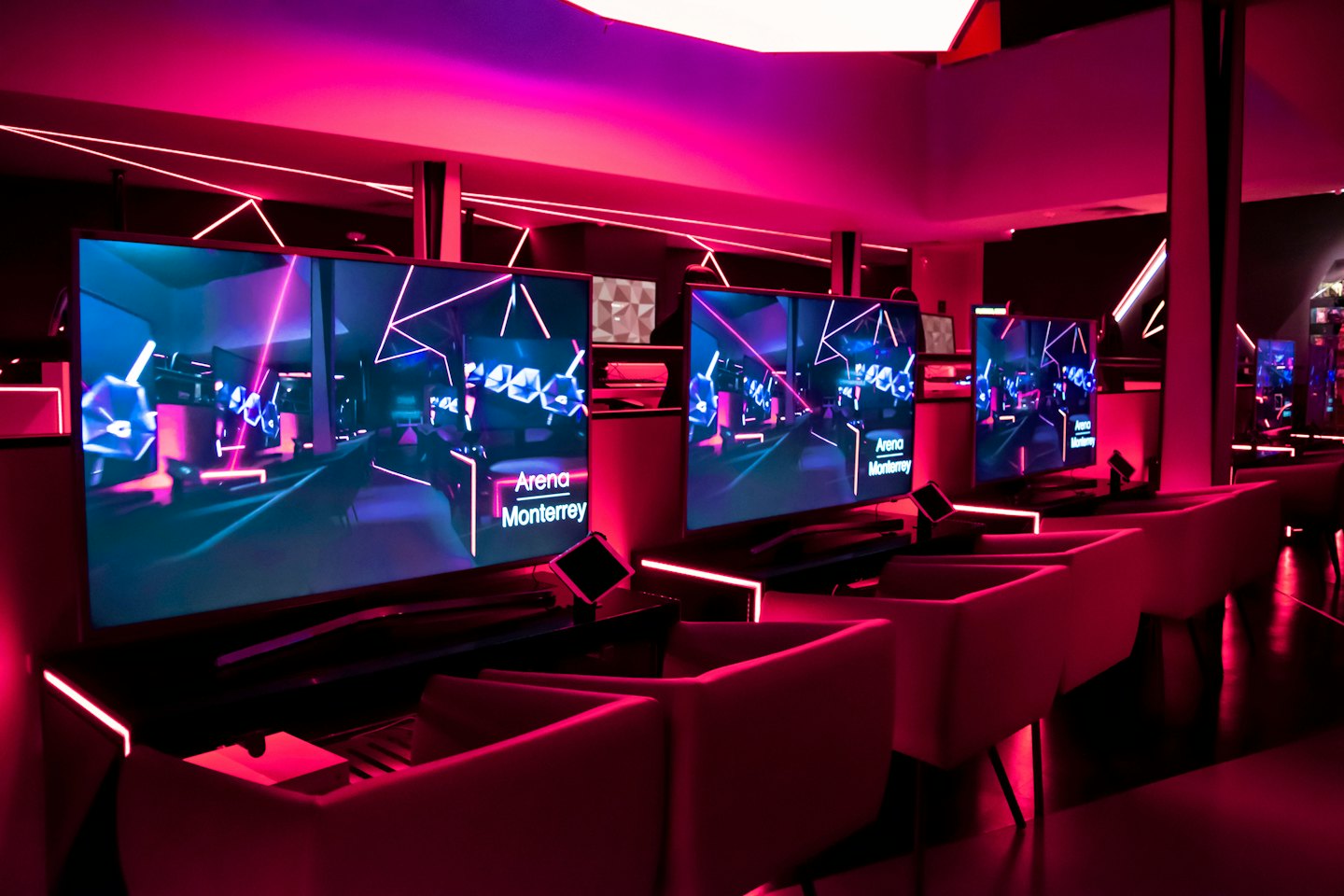 Gaming lounge with neon lights and individual stations.