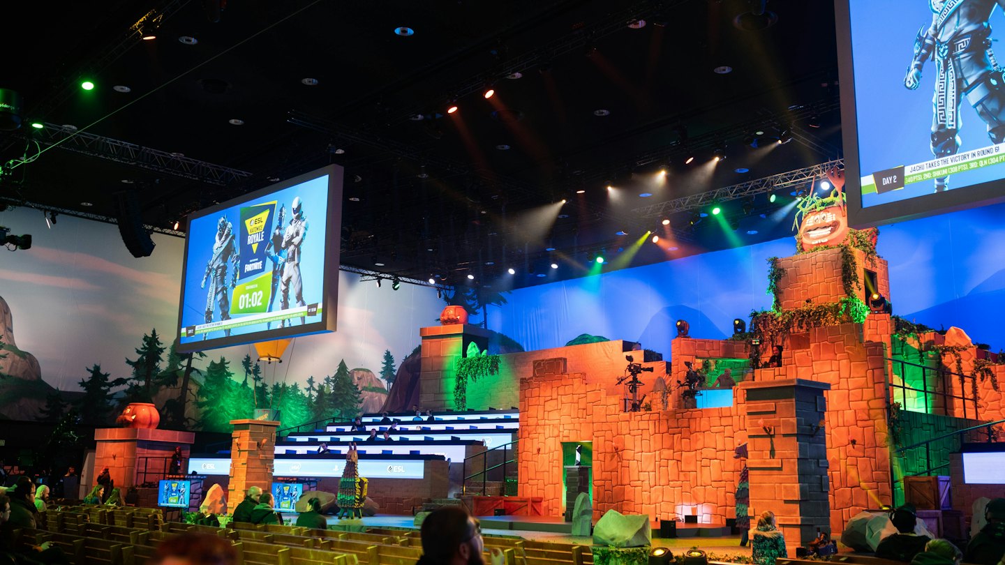 An audience watches a large video game themed esports stage.